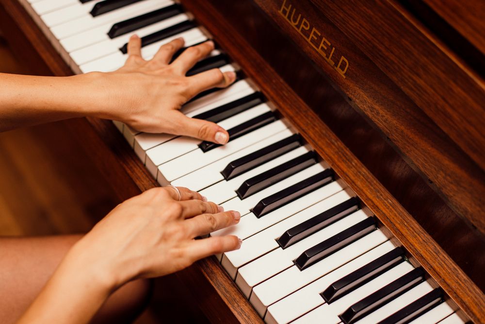 Hands playing a piano during a lesson