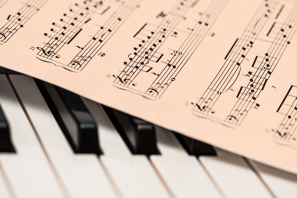 Sheet music resting on piano keys